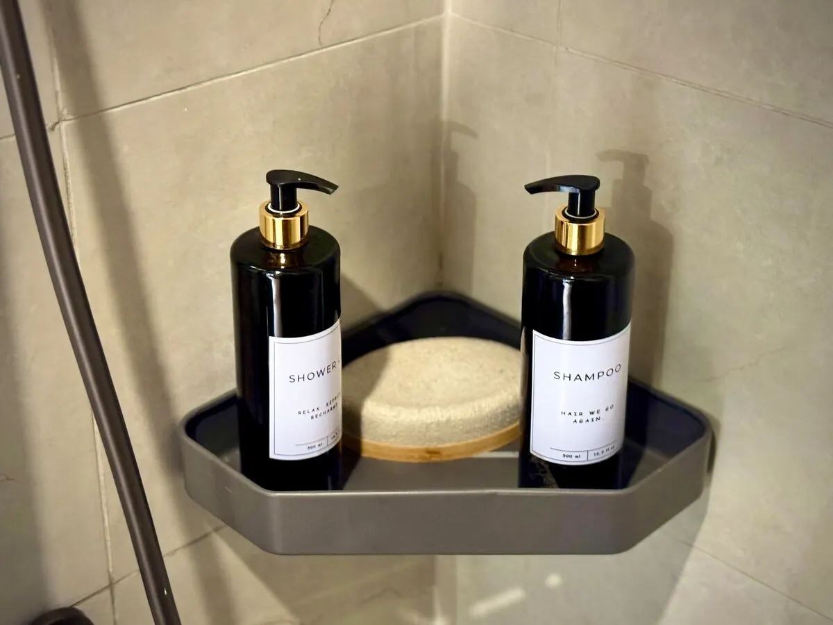 Shower gel and shampoo on a corner shelf