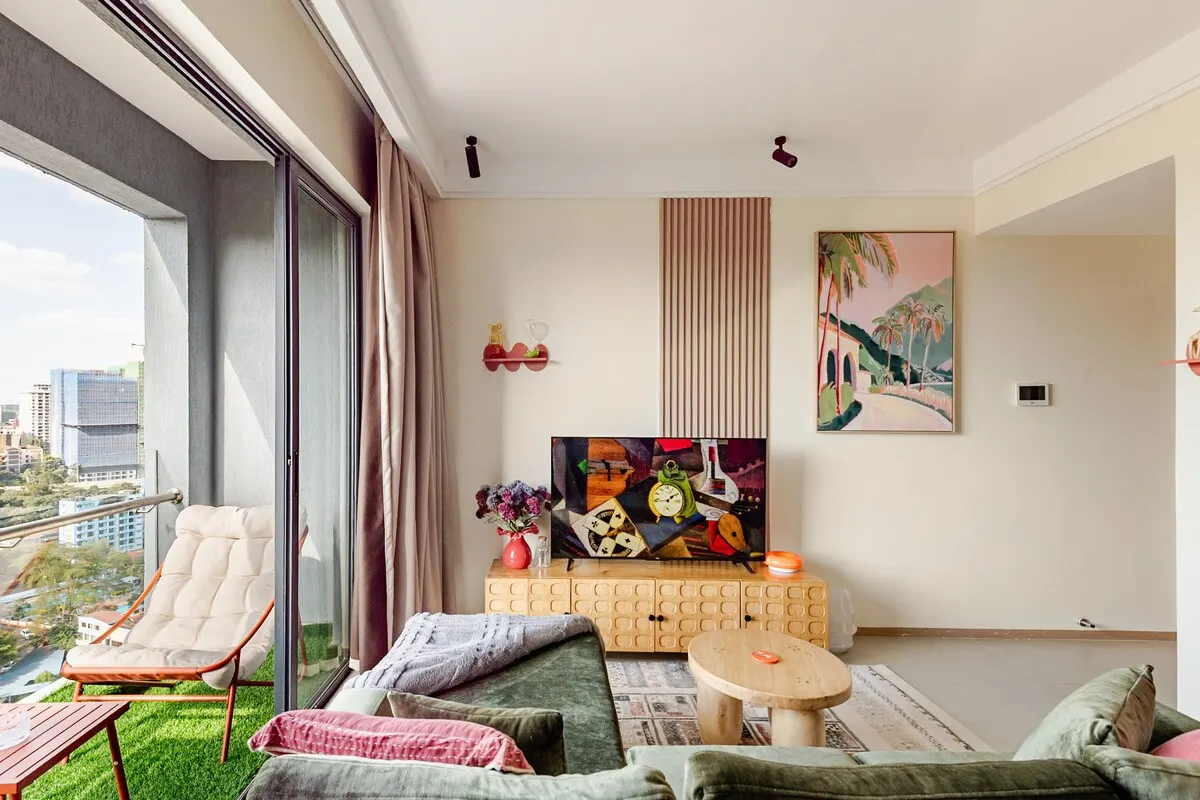 Living room opening onto the balcony, with the TV and artwork